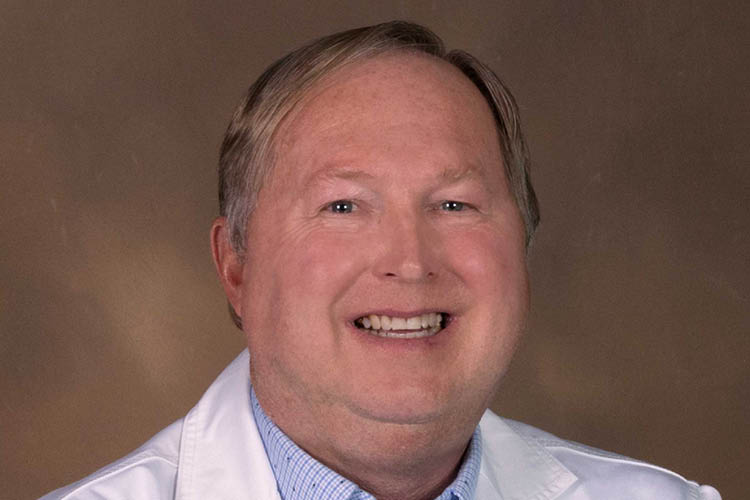 portrait of Dr. Clemenson smiling in a white labcoat