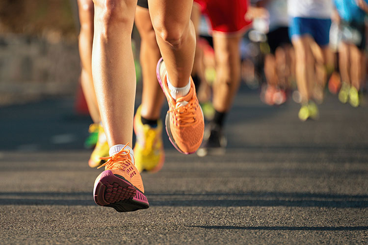 many runners' feet on the pavement during a race