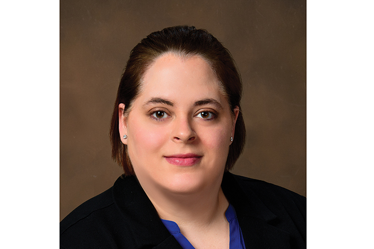 headshot of Lou-Ellen Enman before a tan background
