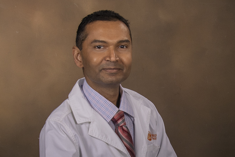 headshot of Dr. Manjunath on a tan background