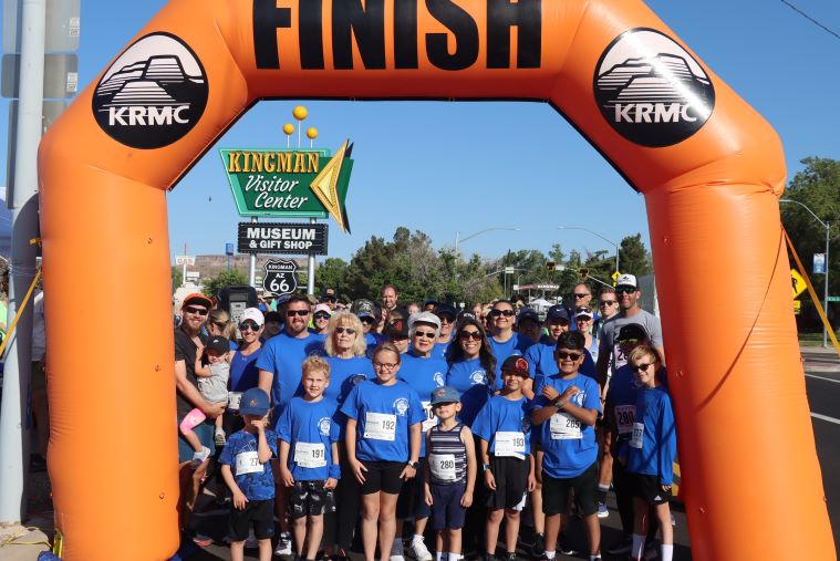 racers stand under an inflatable finish line arch