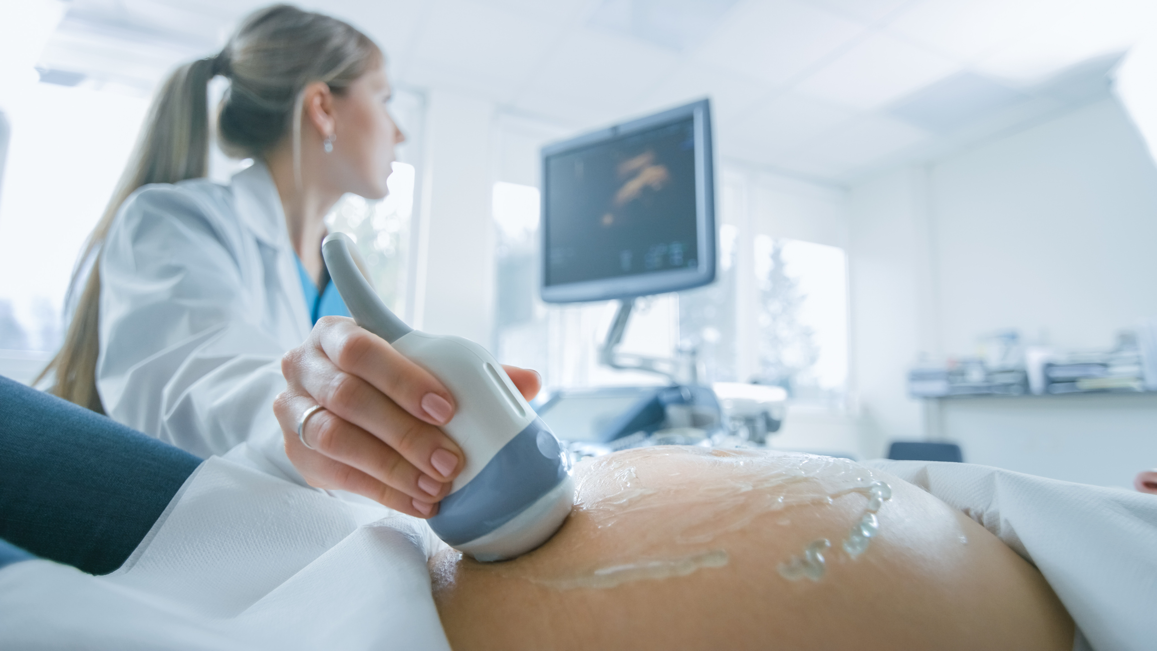 a health professional performs and ultrasound on a pregnant person
