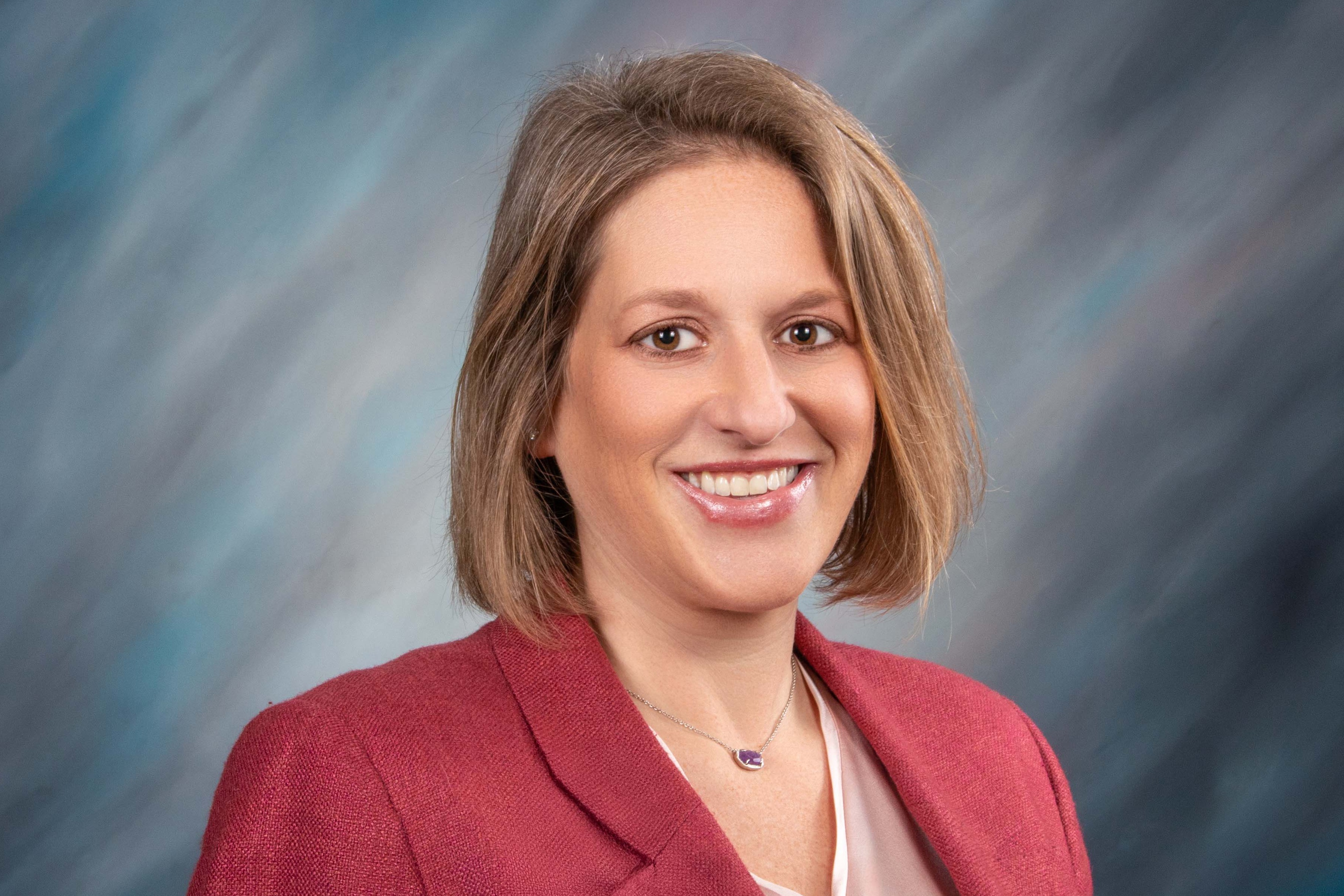 Dr. La Russo smiles before a blue background