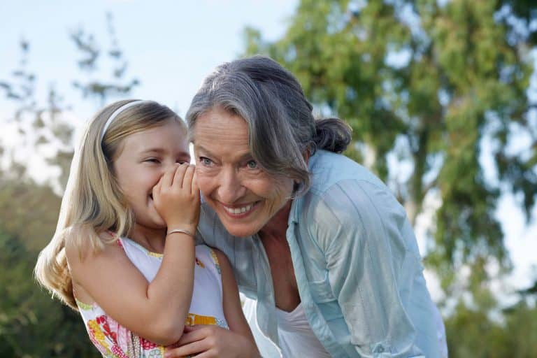 girl whispering to older woman