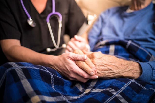 nurse and patient holding hands