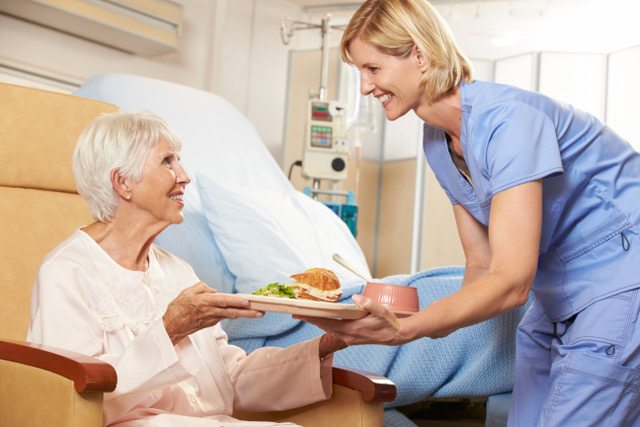 nurse serving meal to patient